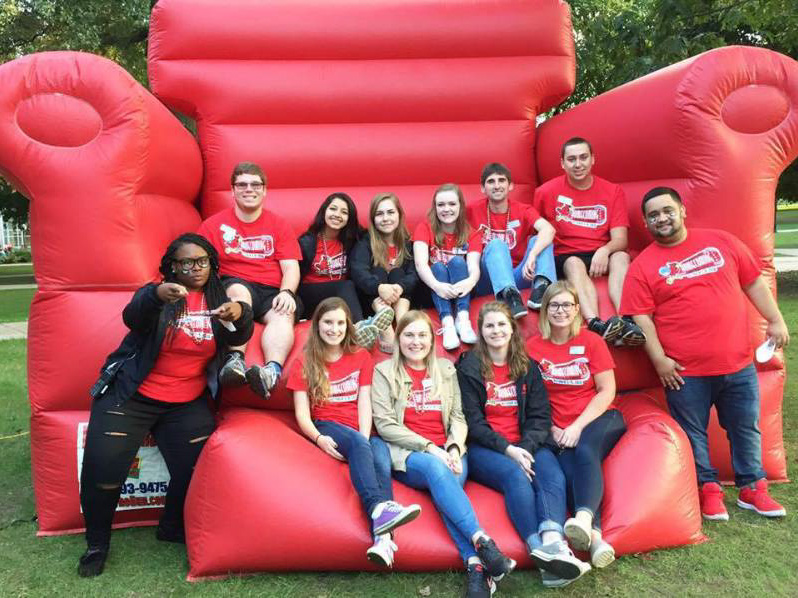 The Leadership Team posing on a big red inflatable chair